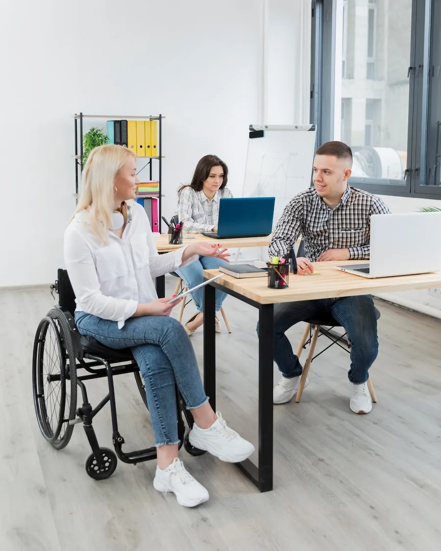 Woman in wheelchair discussing care with support staff